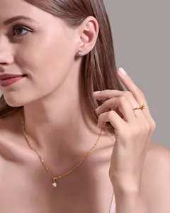 Close-up of elegant gold jewelry set with zircon necklace, earrings and ring on model