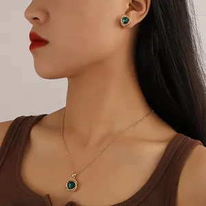 Detail shot of emerald green zirconia jewelry set worn by a model in soft light.