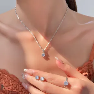 Close-up of elegant silver zircon jewelry set including necklace, earrings and ring on model