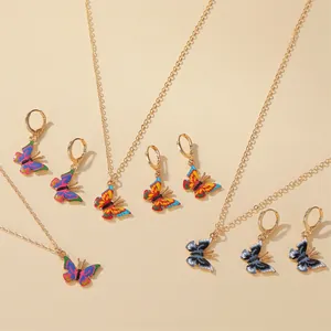 Vibrant butterfly charm necklaces and matching gold-toned hoop earrings detail