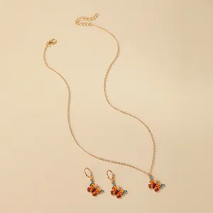 Three piece gold tone jewelry set featuring vibrant multi-color enamel butterfly charms