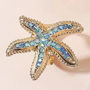 Elegante anello a stella marina dorata con strass scintillanti blu e trasparenti