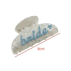 Gros plan de la pince à cheveux bride irisée avec lettrage bleu et mesure de 8cm
