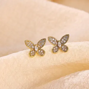 Detailed view of sparkling butterfly stud earrings with gold plating and cubic zirconia