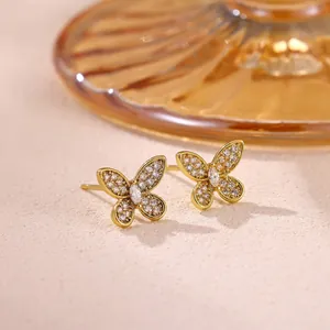 Close-up of sparkling zircon-encrusted butterfly stud earrings in gold finish