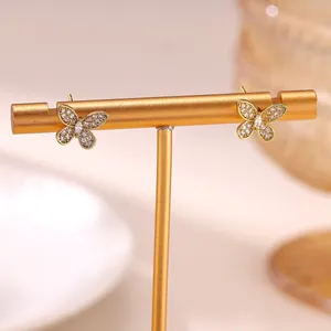 Detailed macro view of golden butterfly stud earrings with sparkling crystals