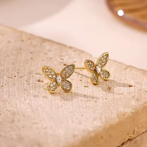 Macro detail of elegant golden butterfly stud earrings inlaid with shimmering cubic zirconia