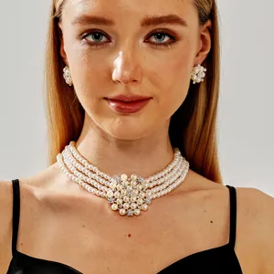 Elegantes mehrreihiges Perlenketten- und Blumen-Ohrring-Set an einem Brautmodell.