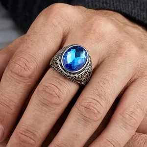 Detailed close-up of vintage engraved titanium steel ring with a bright blue gemstone