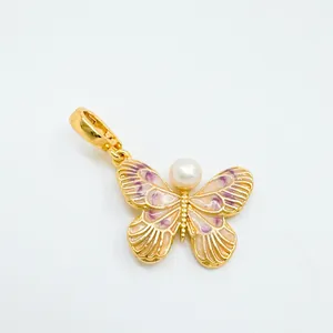 Detailed macro view of an enamel gold-plated butterfly pendant with a white freshwater pearl