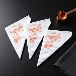 Close-up detail of white disposable piping bags with orange MASTER branding for baking