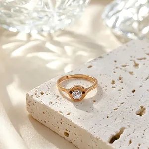 Detalle de un anillo de acero titanio dorado con circón y números romanos en piedra