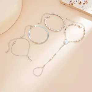Detailansicht eines silbernen minimalistischen Armband-Sets mit Perlen und Kreuz