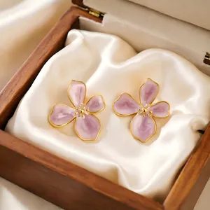 Close-up detail of lavender enamel cherry blossom earrings in a wooden gift box.
