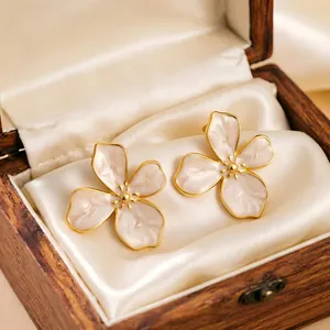 Close-up detail of vintage enamel cherry blossom flower earrings in a wooden jewelry box