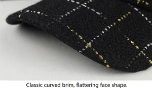 Détail de la visière d'une casquette de baseball en tweed noir avec un motif grille
