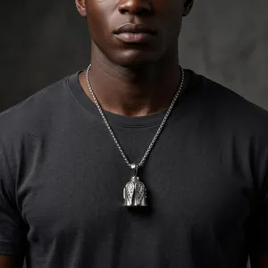 Close-up of a vintage stainless steel bell pendant with wings worn by a male model