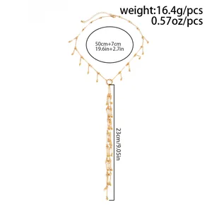 Vue détaillée du collier à pompons dorés indiquant la longueur de 23 cm et le poids.