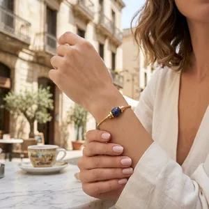 Nahaufnahme eines minimalistischen, vergoldeten Armbands mit blauem Lapislazuli-Stein