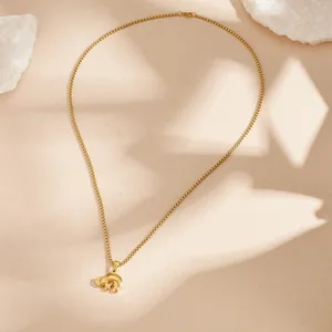Close-up of golden elephant pendant on minimalist vintage stainless steel chain