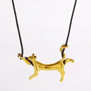 Detailansicht eines goldenen Anhängers in Form einer laufenden Katze an einer Kette