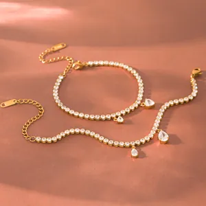 Detailopname van 18K vergulde hart- en traanarmbanden op een elegante warme achtergrond