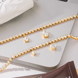 Detail van 18K vergulde tennisarmbanden met schitterende hart- en peervormige zirkonia's.
