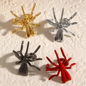 Detailed macro shot of dark gothic spider ear clips in gold, silver, black, and red colors.