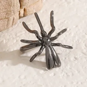 Macro detail of a dark metallic spider ear cuff showing the intricate gothic design.