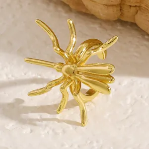 Detailed macro view of a gold spider ear cuff showing its shiny metallic texture