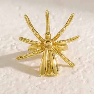 Macro view of a stylized gold spider ear cuff with a glossy metallic finish for Halloween