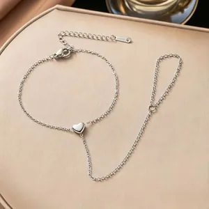 Detail of silver stainless steel heart hand chain bracelet showing delicate link texture