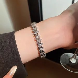 Primer plano detallado de una pulsera segmentada de circonitas plateadas en la muñeca