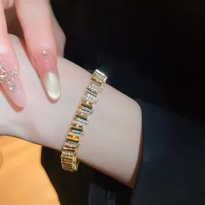 Vista macro detallada de una lujosa pulsera chapada en oro de 18k con circonitas en la muñeca