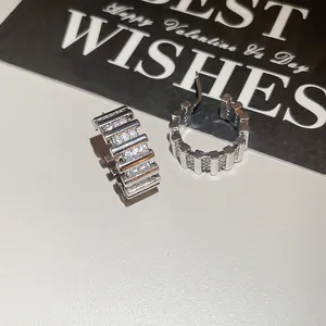 Detalle de pendientes de aro chapados en oro 18k con circonitas y diseño de rayas.