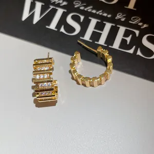 Vista detallada de los pendientes de aro chapados en oro de 18k con piedras de circón.