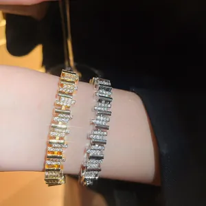 Primer plano de elegantes pulseras de circón bañadas en oro de 18k y plata en una muñeca