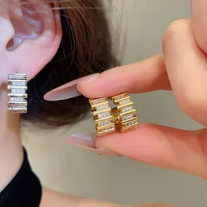 Detalle de pendientes de lujo bañados en oro de 18k con circonitas