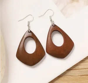 Close-up of bohemian geometric teardrop wood earrings with silver-tone hooks