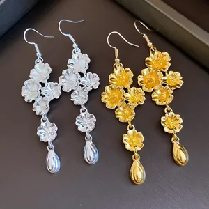 Vista di dettaglio di orecchini pendenti vintage a fiori con goccia in finitura oro e argento