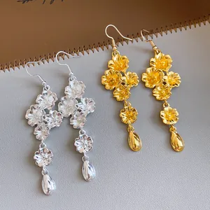 Vista dettagliata di orecchini a fiore vintage con pendenti a goccia in oro e argento