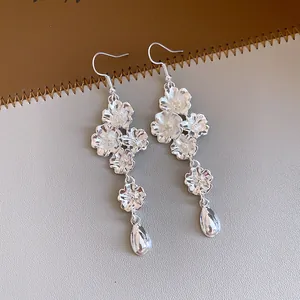 Dettaglio macro di orecchini vintage in argento con motivi floreali e eleganti pendenti a goccia