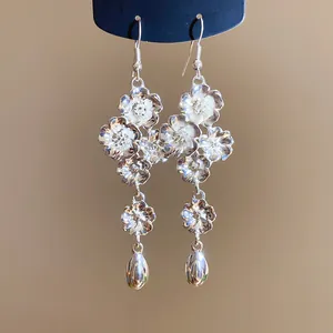 Primo piano di orecchini vintage a fiori in argento con ciondolo a goccia lucido