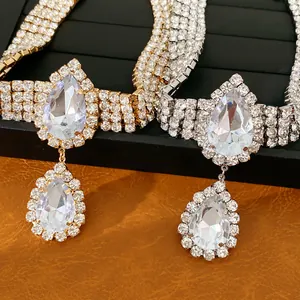 Gros plan de colliers en cristal goutte d'eau en or et argent avec des strass brillants.