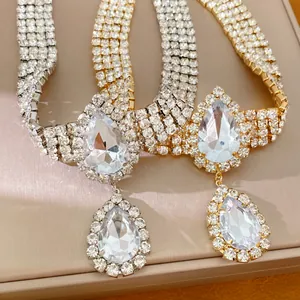 Gros plan de colliers gouttes de luxe avec strass en finitions or et argent.