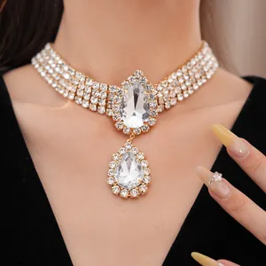 Vue détaillée d'un élégant collier ras du cou doré orné de grands cristaux en forme de larme