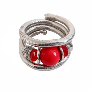 Multi-layer silver metal wrap bracelet with red acrylic beads and faceted crystals.