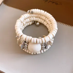 Detailed view of a vintage multilayer wrap bracelet featuring cream beads and silver metal balls