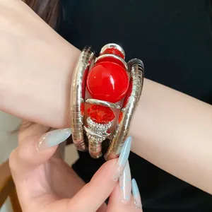 Close-up of a multi-layer metal wrap bracelet with vibrant red acrylic beads.