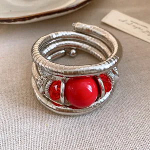 Close-up of vintage multi-layer silver spiral bracelet with red acrylic beads